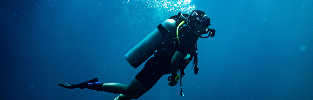 A SCUBA diver swims through open water.
